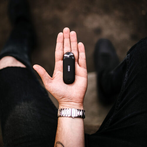 Person Holding Black Vape in Palm of Hand